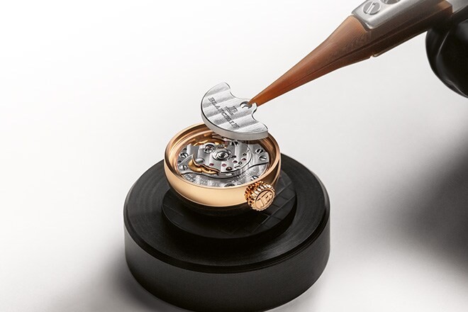 A watchmaker working on a Lady B held in a fixture