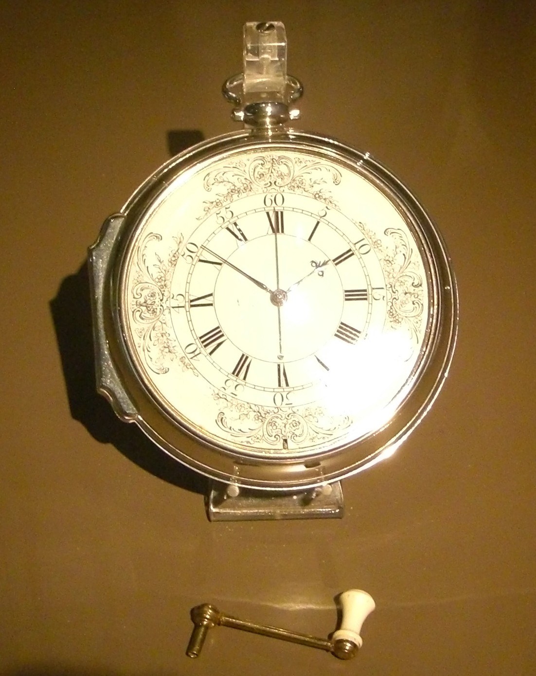 The white enamel dial of H4 with Roman numerals, in its silver case